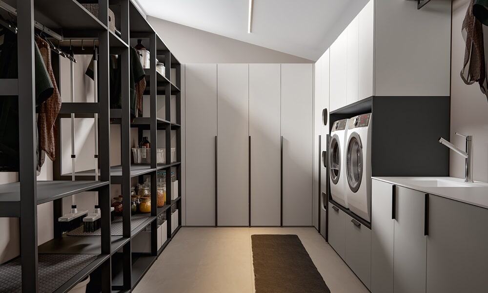 Efficient laundry room featuring stylish cabinets and ample storage for clothes and cleaning supplie.