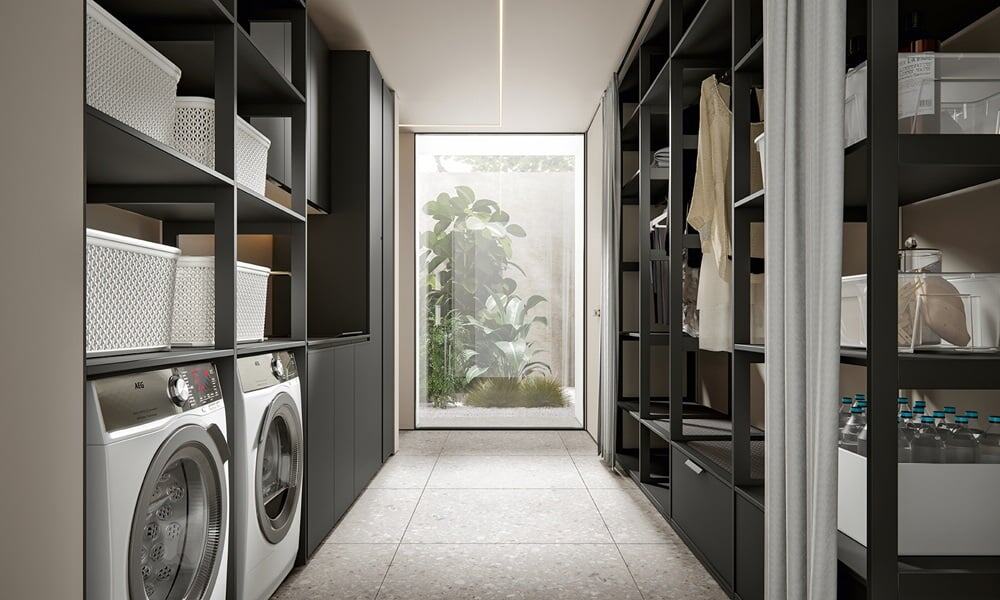 Modern laundry room with black cabinets, washer, and organized storage.