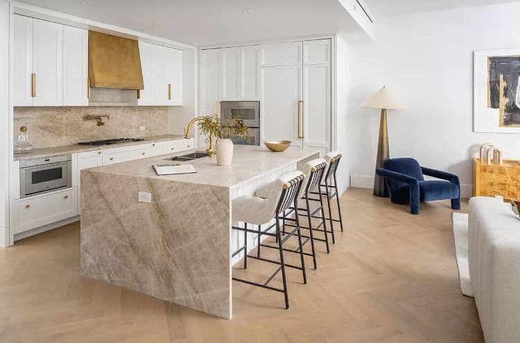 Urban home kitchen with sleek white cabinetry and marble island.