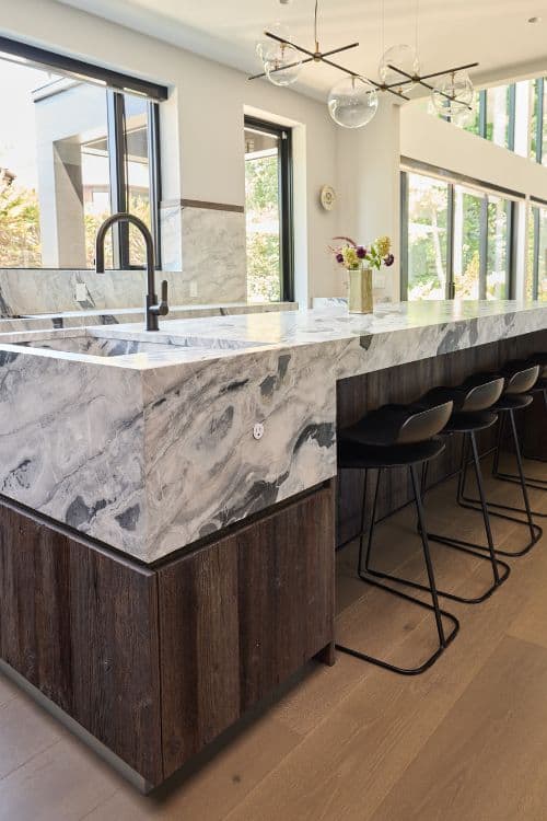 Bright modern farmhouse kitchen with marble island and large windows in northern New Jersey.