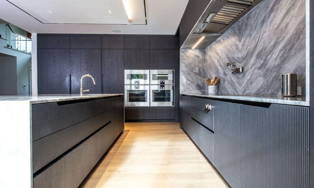 Contemporary urban kitchen featuring sleek dark cabinetry and marble backsplash.