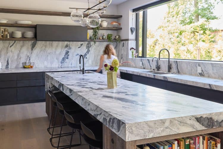 Modern farmhouse kitchen with marble countertops and large window in northern New Jersey.