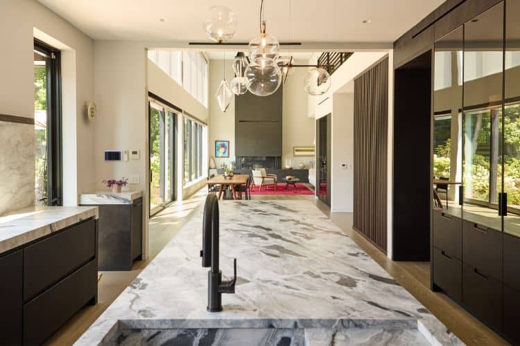 Spacious modern urban home kitchen with marble island and sleek cabinetry.