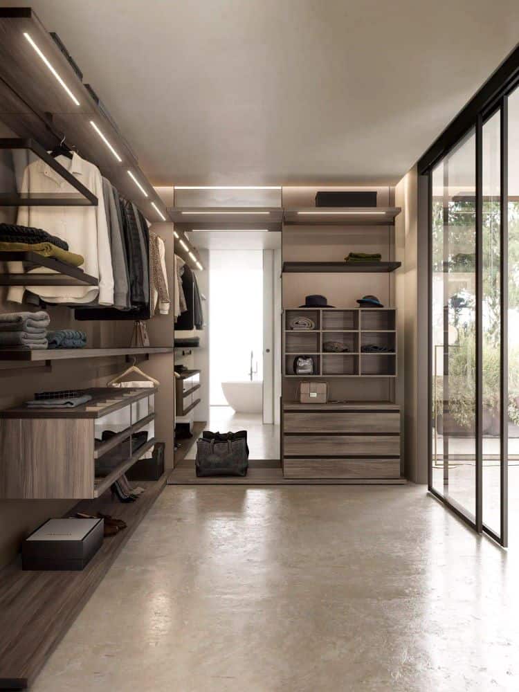 Modern walk-in closet with organized shelves and glass sliding doors for stylish storage.