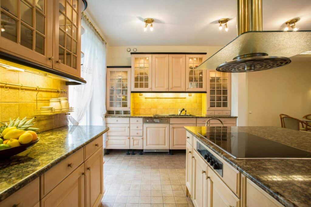Bright urban kitchen featuring cream cabinets, granite countertops, and modern appliances. Well-lit.