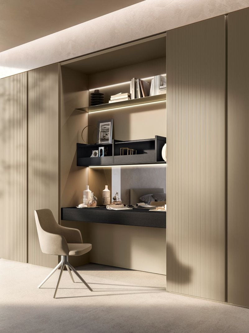 Luxury hidden home office integrated into custom cabinetry with fluted doors, floating desk, illuminated shelving, and concealed workspace design.