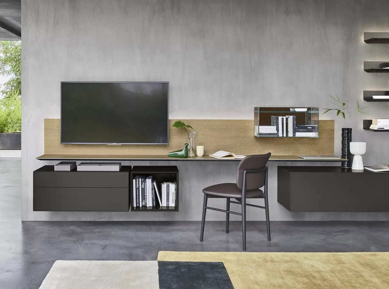 Modern floating home office with wall-mounted desk, custom storage cabinets, open shelving, and integrated TV in a contemporary NYC residence.
