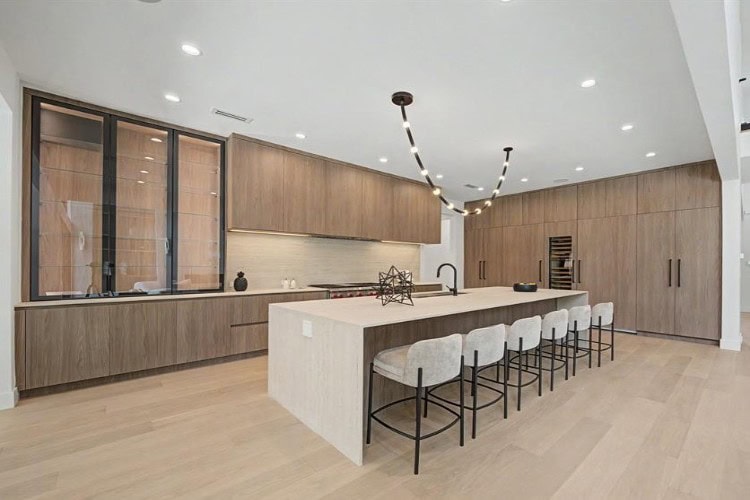 Modern Italian kitchen in New Jersey with custom wood cabinets, quartz waterfall island, integrated appliances, and luxury European cabinetry by Urban Homes.
