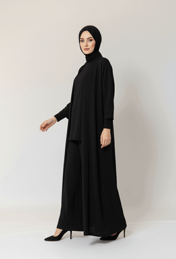Woman wearing a stylish black abaya and hijab, full-length modest fashion outfit.