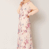 Elegant woman in floral maxi dress with beige hijab, showcasing modest fashion and contemporary styl.
