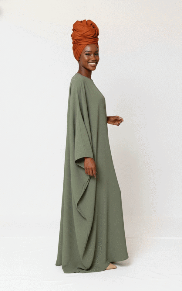 Beautiful woman wearing a stylish green modest dress with a matching headwrap, perfect for special occasions.