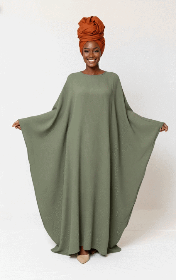 Beautiful woman wearing an olive green flowing dress paired with a stylish burnt orange headwrap.
