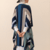 Elegant woman wearing a stylish geometric patterned shawl and wide-brim hat, showcasing Umeed Design.