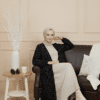 Modest fashion woman wearing beige and black polka dot outfit with cream boots.