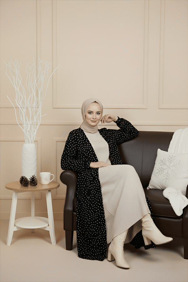 Modest fashion woman wearing beige and black polka dot outfit with cream boots.