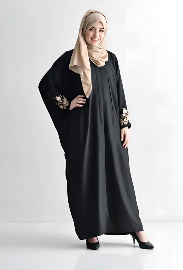 Woman wearing a stylish black abaya with intricate embroidery on sleeves.