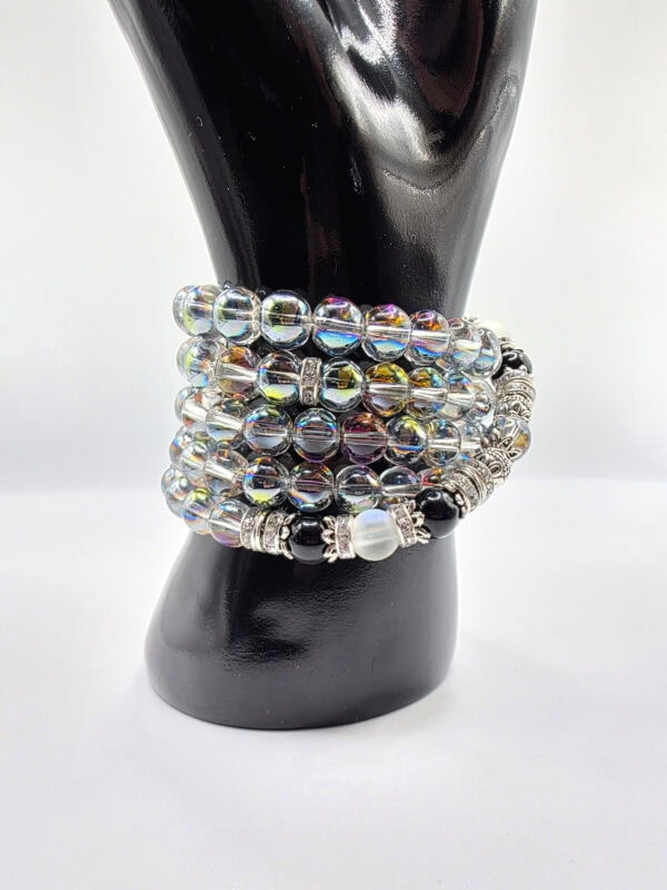 Colorful beaded bracelets stacked on a black display stand, showcasing vibrant and stylish jewelry.