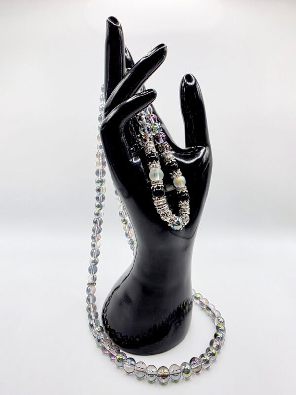 Elegant jewelry display featuring beaded necklaces and bracelets on a black mannequin hand.