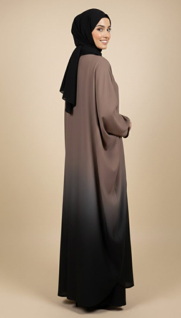 Woman wearing a stylish gradient abaya with black hijab, full-length modest fashion.