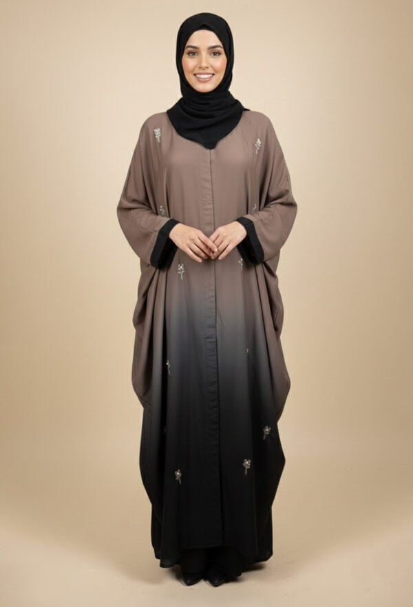 Woman wearing a stylish, embellished abaya with a black hijab, standing confidently.