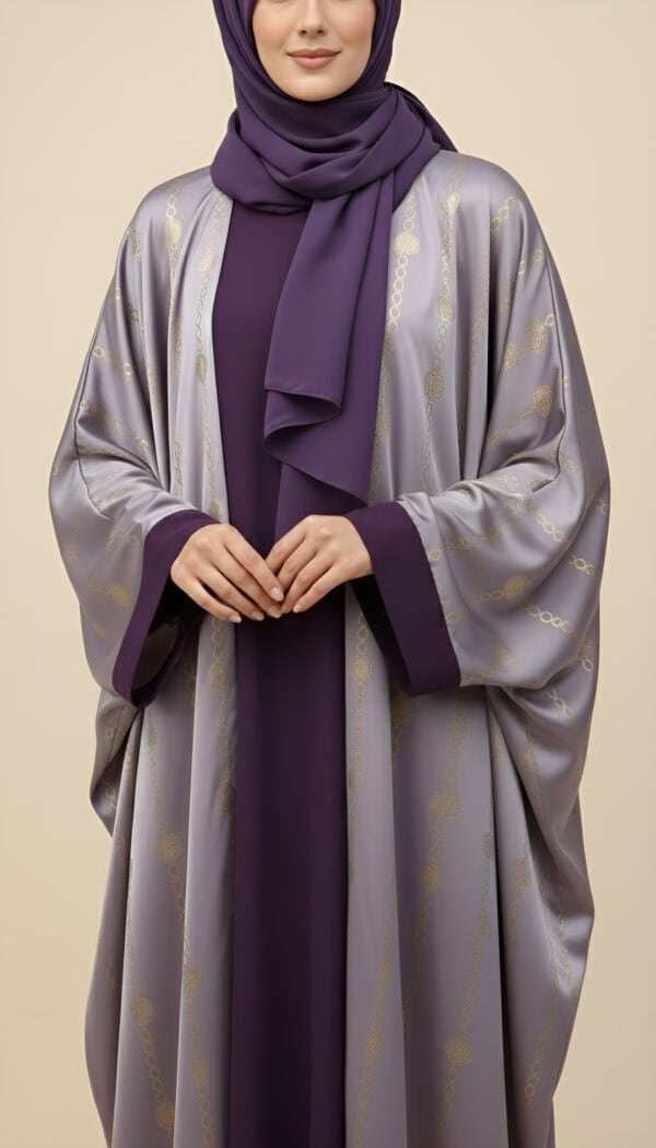 Woman wearing a stylish purple abaya with gold details and matching hijab.