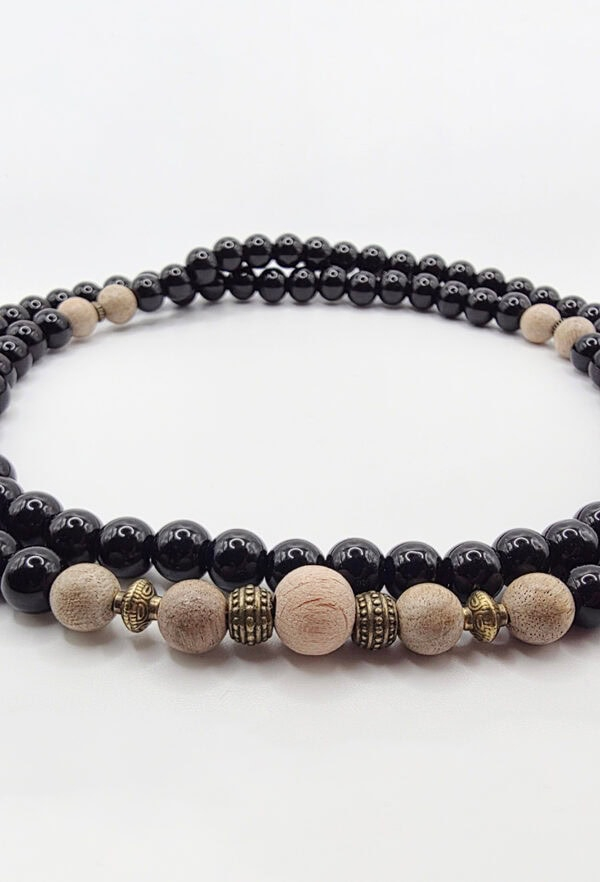 Elegant beaded necklace featuring black, beige, and gold accents for a sophisticated look.