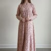 Woman wearing a floral maxi dress with long sleeves and a V-neckline.