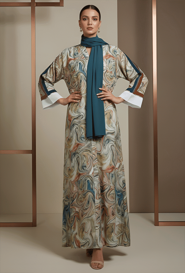 Woman wearing a marble print maxi dress with a blue scarf, standing confidently indoors.