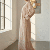 Woman wearing a floral maxi dress in a minimalist studio setting.