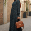 Elegant modest floral dress with a rust-colored hijab and matching handbag.