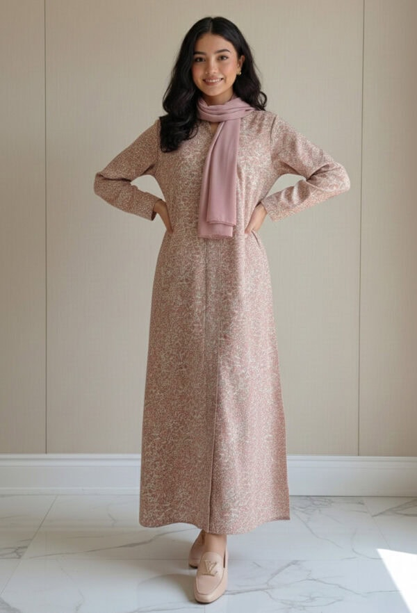 Woman wearing a pink embroidered dress with matching scarf, standing indoors.