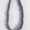 Beaded necklace with red central bead and metallic accents, perfect for stylish accessories.