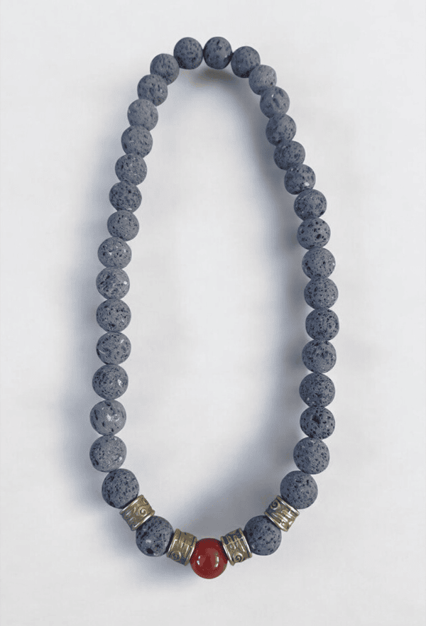 Beaded necklace with red central bead and metallic accents, perfect for stylish accessories.