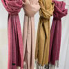 Elegant wool scarves in pink, beige, mustard, and maroon hanging on a rack. Perfect for stylish wint.