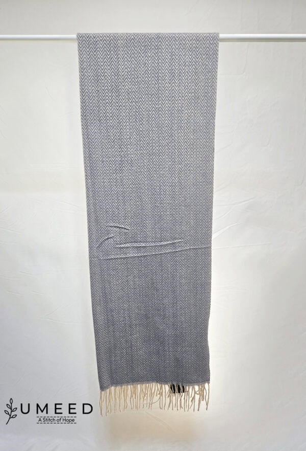 Gray woven textile with subtle zigzag pattern and fringed edges.