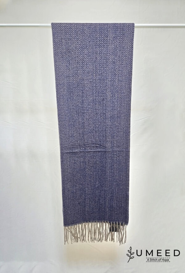 Handwoven blue scarf with intricate patterns and fringed edges, perfect for stylish winter accessori.