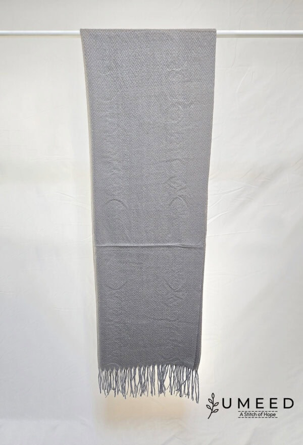 Grey handwoven scarf with intricate patterns and fringed edges, perfect for stylish winter accessori.