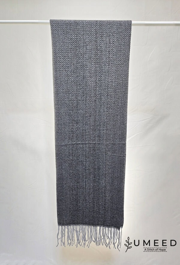 Elegant woven scarf with intricate pattern and fringed edges, perfect for stylish winter accessories.