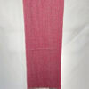 Pink handwoven scarf with intricate patterns, showcasing craftsmanship and vibrant color.