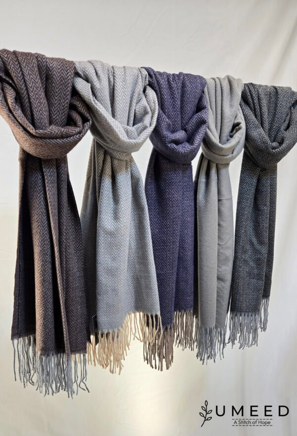Wool scarves in gray, blue, and beige tones displayed on a hanger.