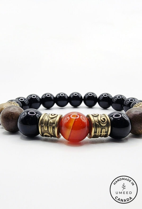 Elegant beaded bracelet with black, brown, and orange stones, accented with brass, showcasing handcr.
