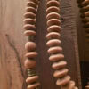 Close-up of handmade wooden beaded necklace with metallic accents from Umeed Designs.