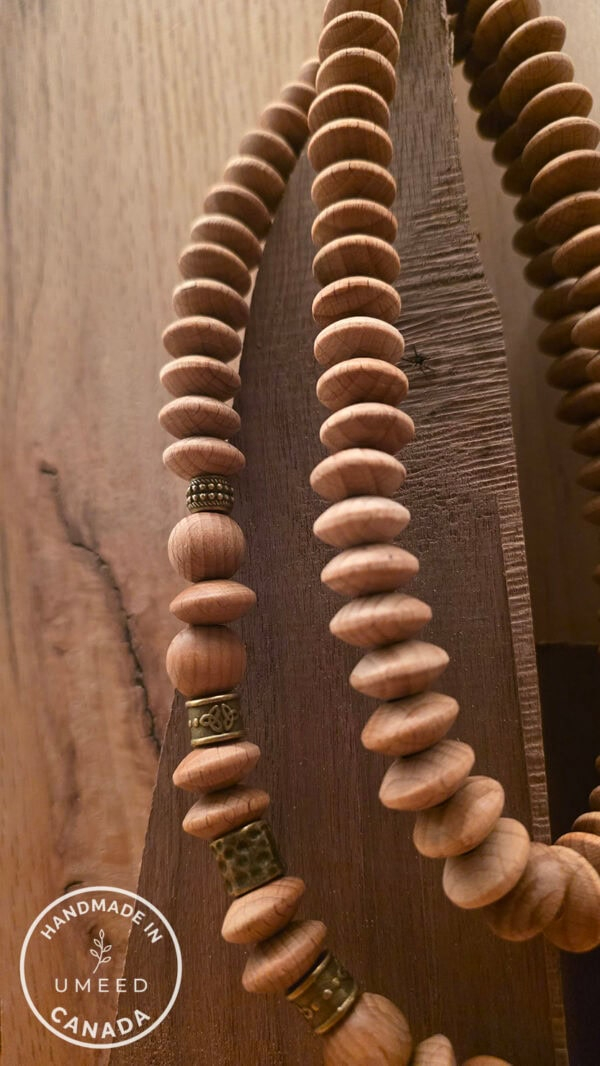 Close-up of handmade wooden beaded necklace with metallic accents from Umeed Designs.