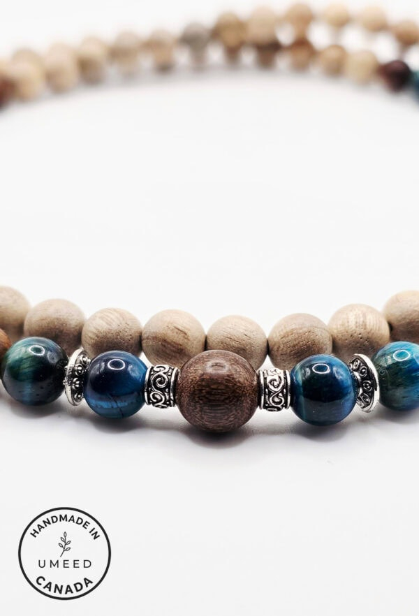 Bracelet with natural wood and blue beads, accented with silver charms, showcasing handcrafted jewel.