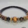 Elegant handmade beaded necklace with black, gold, and brown beads, showcasing craftsmanship and uni.