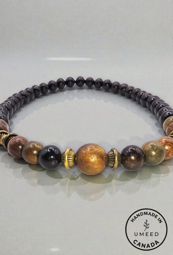 Elegant handmade beaded necklace with black, gold, and brown beads, showcasing craftsmanship and uni.
