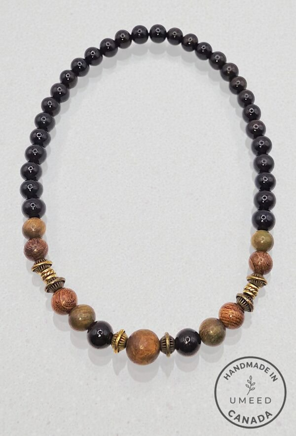 Handmade beaded necklace with black, brown, and gold beads from Umeed Designs.