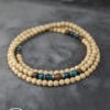 Elegant beaded necklace featuring natural wood beads and blue accents, handcrafted by Umeed Designs.