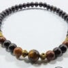 Handmade beaded necklace featuring black, brown, and gold accents from Umeed Designs.