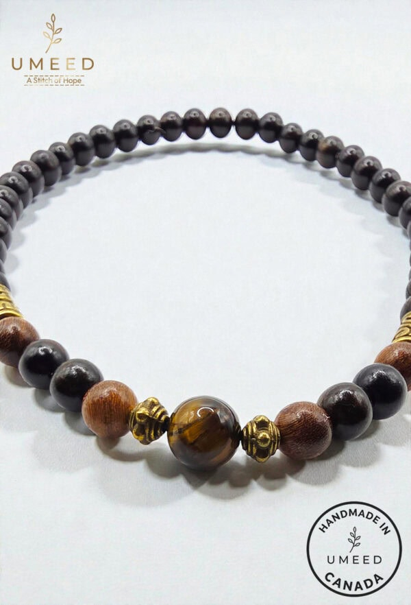 Handmade beaded necklace featuring black, brown, and gold accents from Umeed Designs.